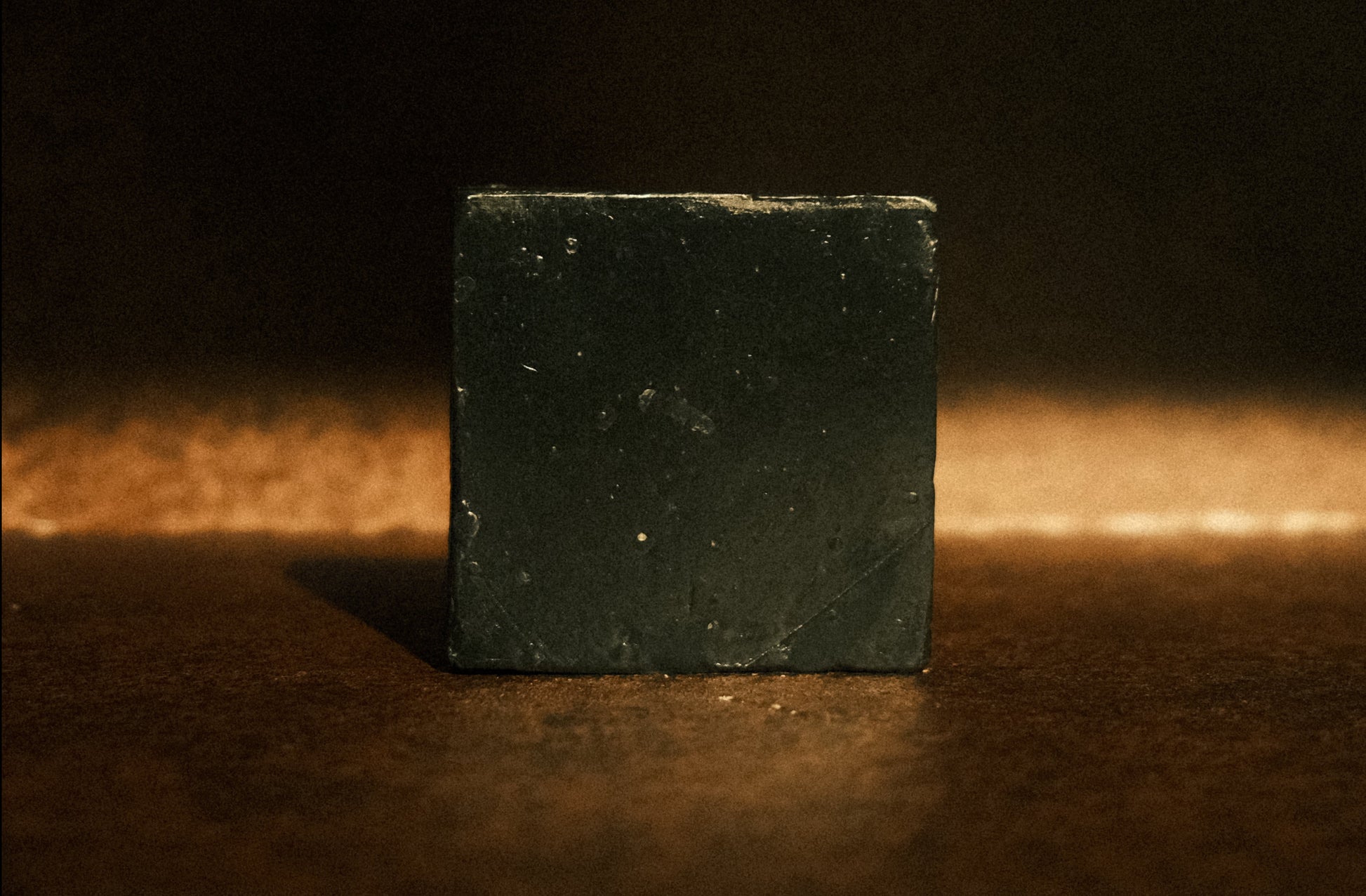 Black bar soap on brown background