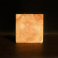 Orange swirled bar of soap standing with brown background