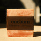 Bar of marbled orange soap with a brown label, “oudbom, coastal citrus”