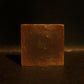 Brown bar of soap standing with brown background