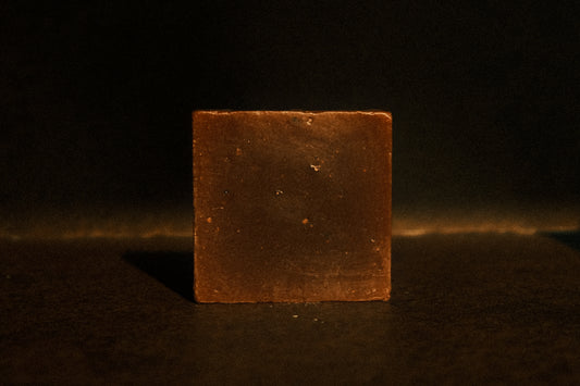 Brown bar of soap standing with brown background