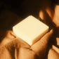 White bar of soap laying on light brown cloth