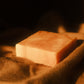 Orange swirled bar of soap laying on brown cloth