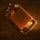 Top down view of a brown bar of soap laying on a tan soap dish with oats and star anise garnishing it