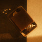 Top down view of a brown bar of soap laying on a tan soap dish with oats and star anise garnishing it