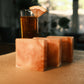 Orange swirled bars of soap standing in ascending order with orange drink in the background