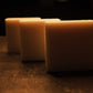 White bars of soap lightly illuminated by warm light, brown floor